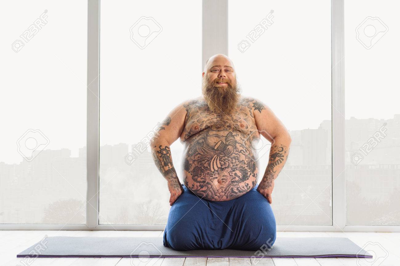 68751191-joyful-mature-fat-man-doing-yoga-at-home.jpg