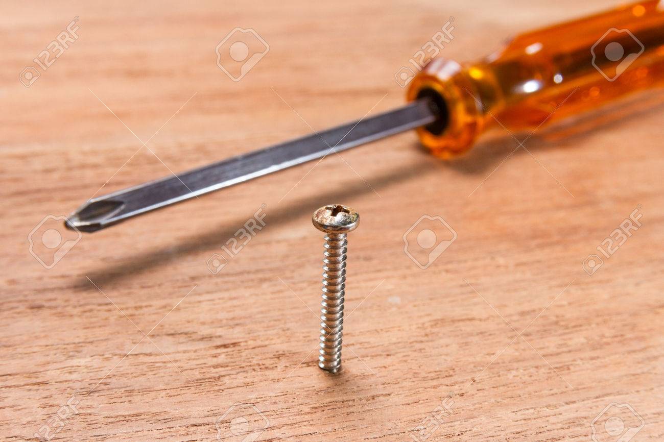 47464808-orange-screwdriver-and-screw-on-wood-background.jpg