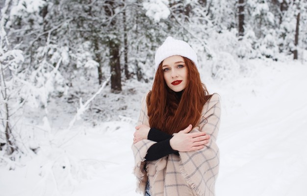 young-red-haired-girl-with-long-red-hair-winter-background-red-haired-woman-white-hat-backgrou...jpg